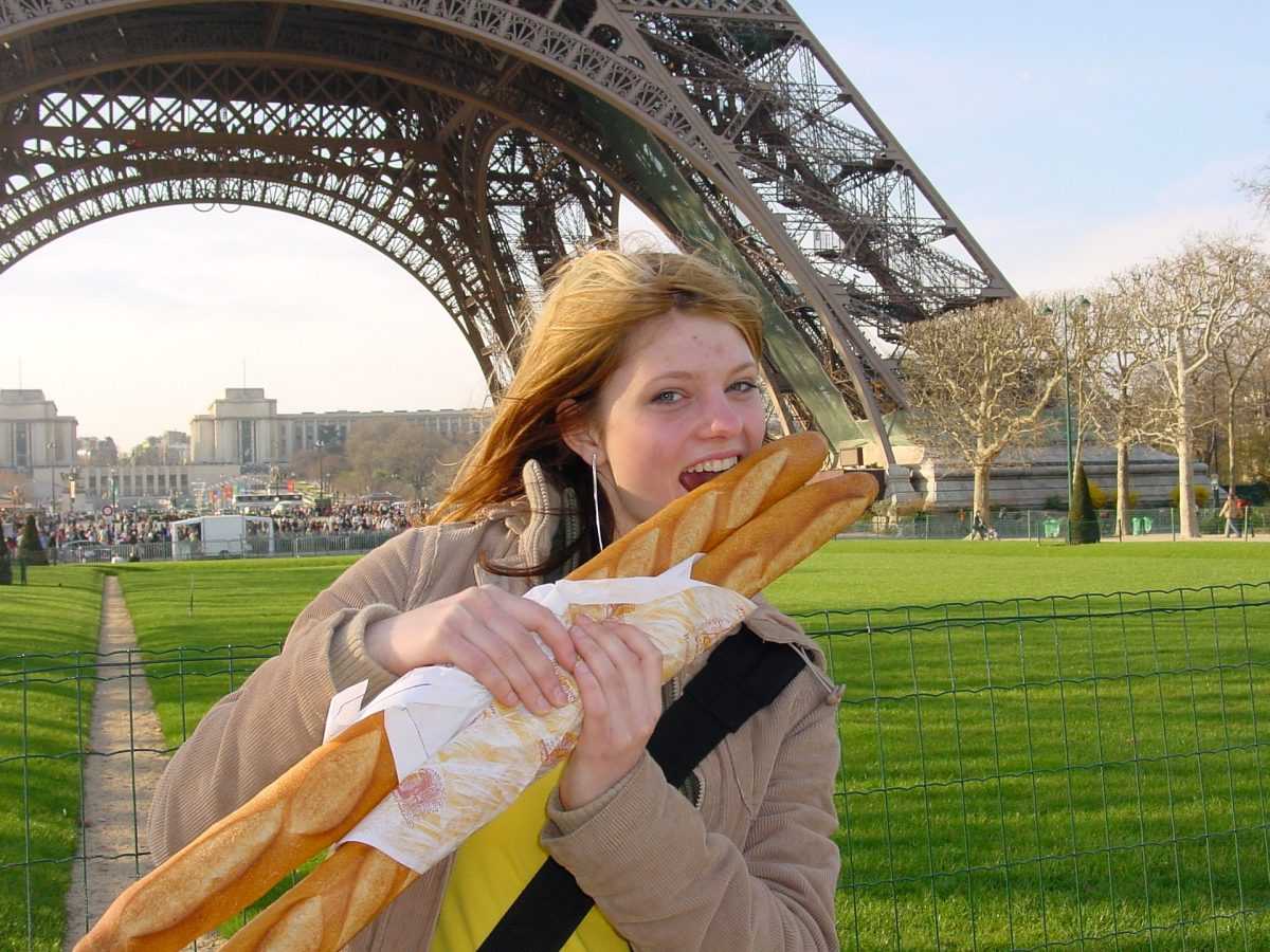 Девушка с багетом на фоне Эйфелевой башни